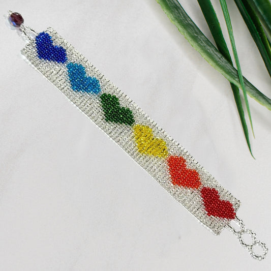Beaded bracelet with colorful heart-shaped beads on silver background
